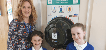 Students from Ysgol Bryn Coch school with their new defibrillator